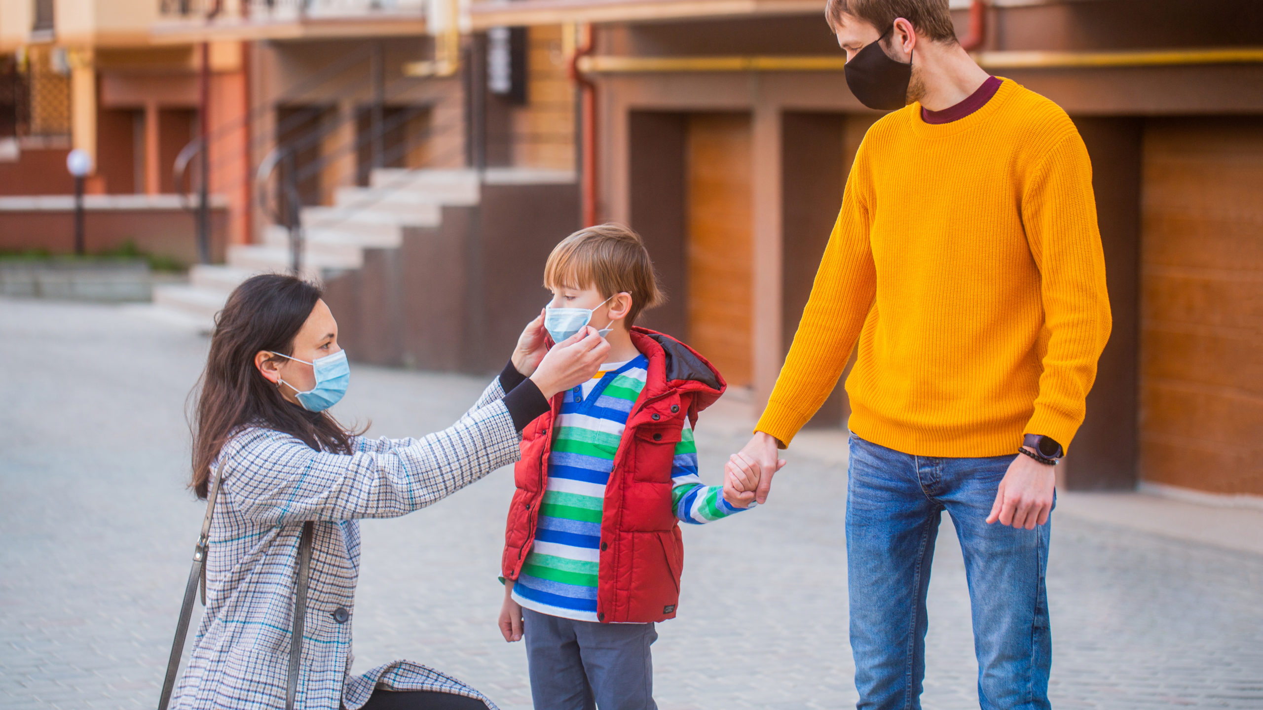 Child with parents wearing masks during COVID-19