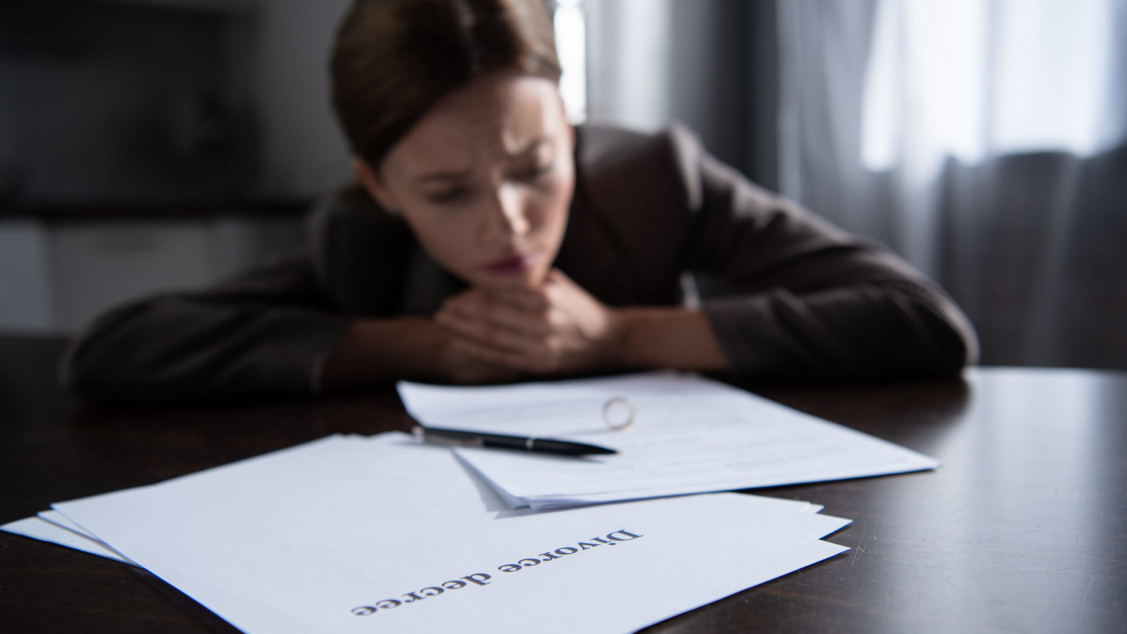 sad woman at table with divorce documents