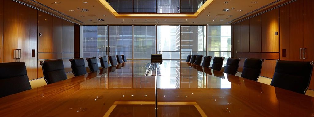 a sophisticated office meeting room with a polished conference table, where a diverse group of engaged couples reviews an elegant, clear prenuptial agreement, reflecting a sense of collaboration and thoughtful planning.